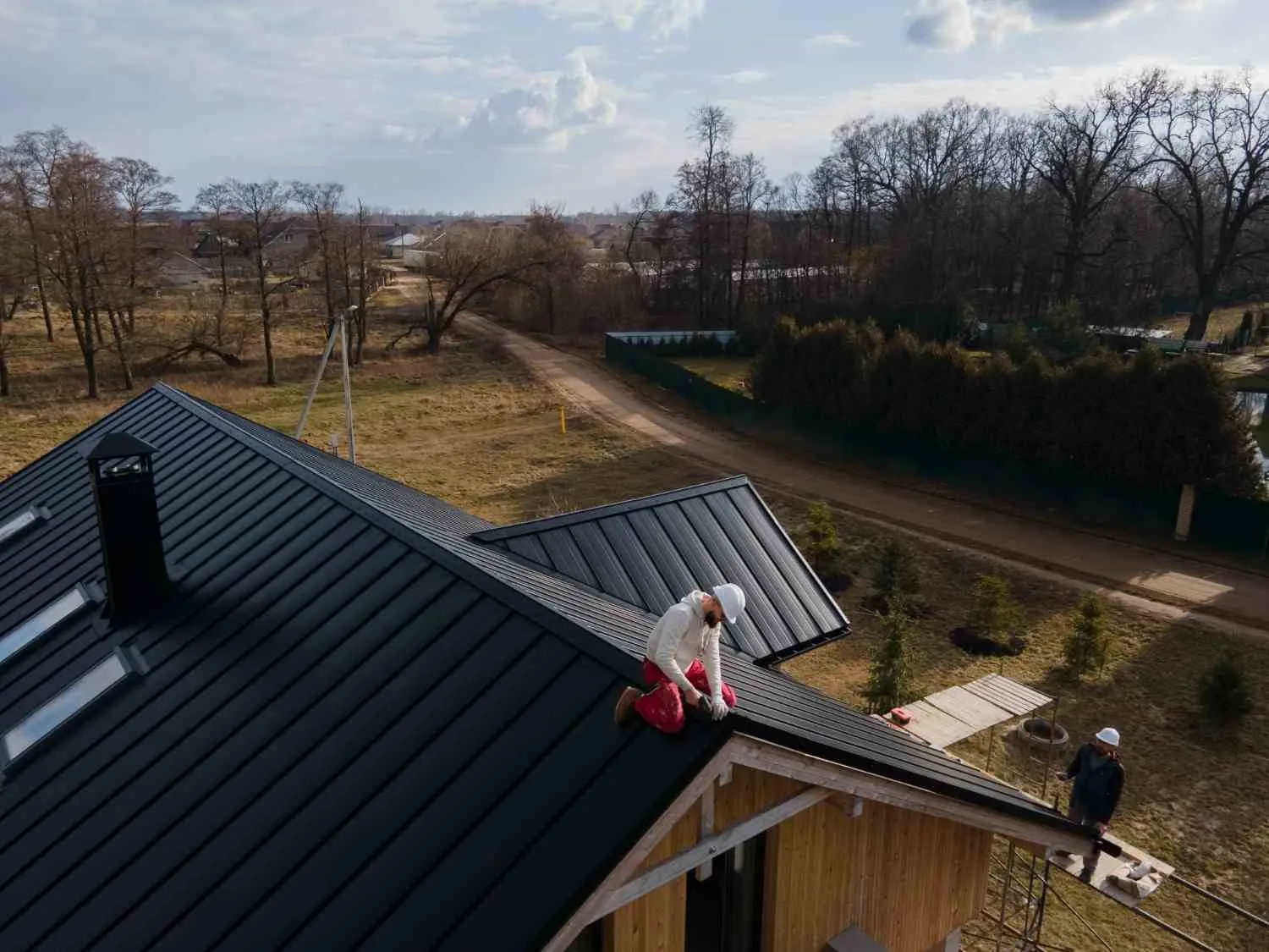 Roofer fitting new shingles along the slope of a house roof